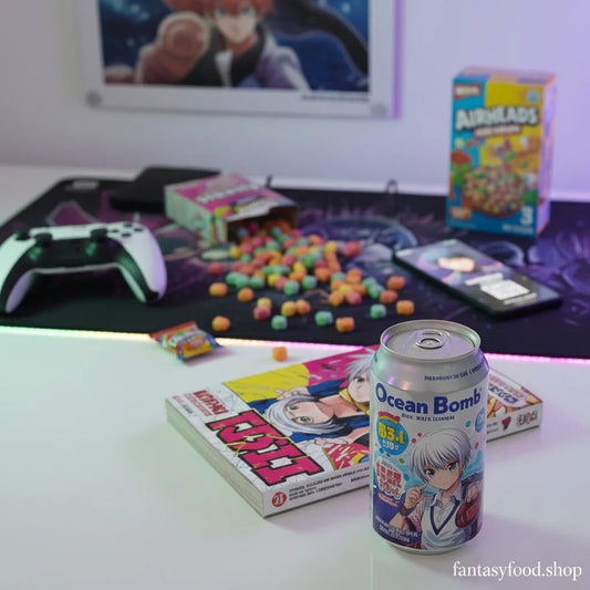 Lattina Ocean Bomb in edizione limitata anime su una scrivania da gaming con manga, snack americani Airheads e controller, atmosfera pop e luminosa per Fantasy Food.